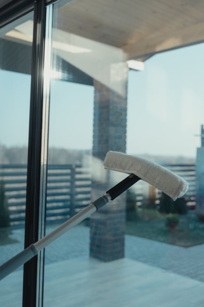 Un outil de nettoyage moderne utilisé pour nettoyer une grande fenêtre en verre avec une vue dégagée sur l’extérieur.